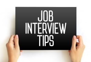 Hands holding a board that says job interview tips